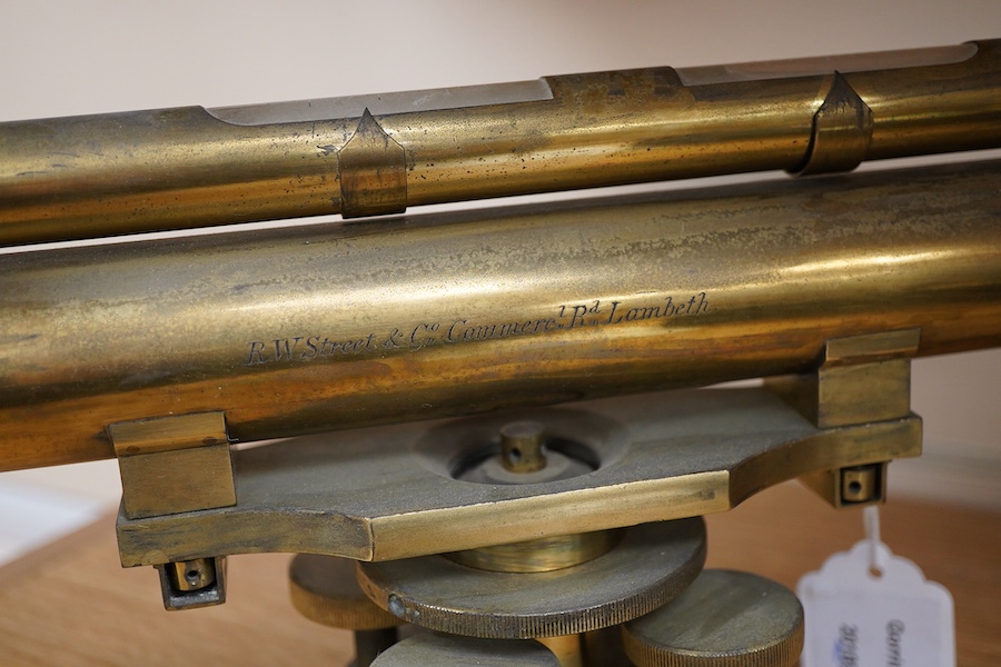 A late 19th century lacquered brass level, by R.W. Street & Co., Commerce Rd., Lambeth, with an incorporated 16 inch telescope, with an ash tripod, uncased, 41cm long